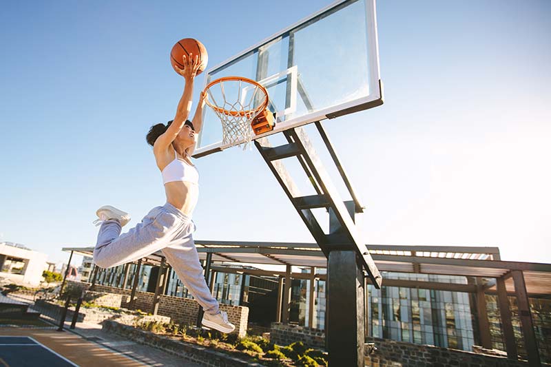 woman slam dunking a basketball